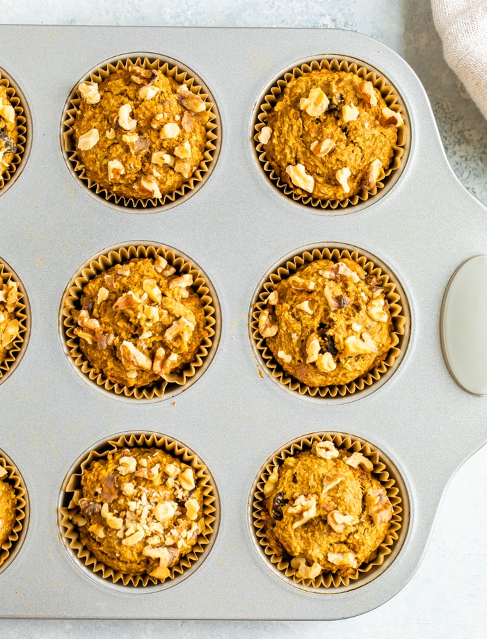 Muffin tin with oat bran muffins topped with walnuts.