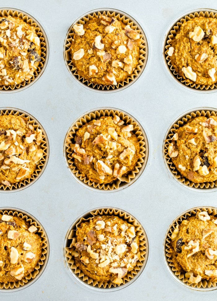 Muffin tin with oat bran muffins topped with walnuts.