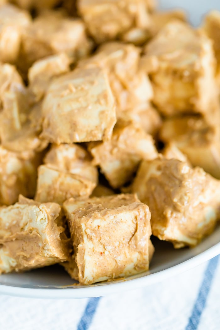 Cubes of tofu coated in a peanut sauce before being baked.