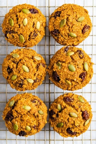 Six pumpkin bran muffins on a cooling rack, view from above the muffins.