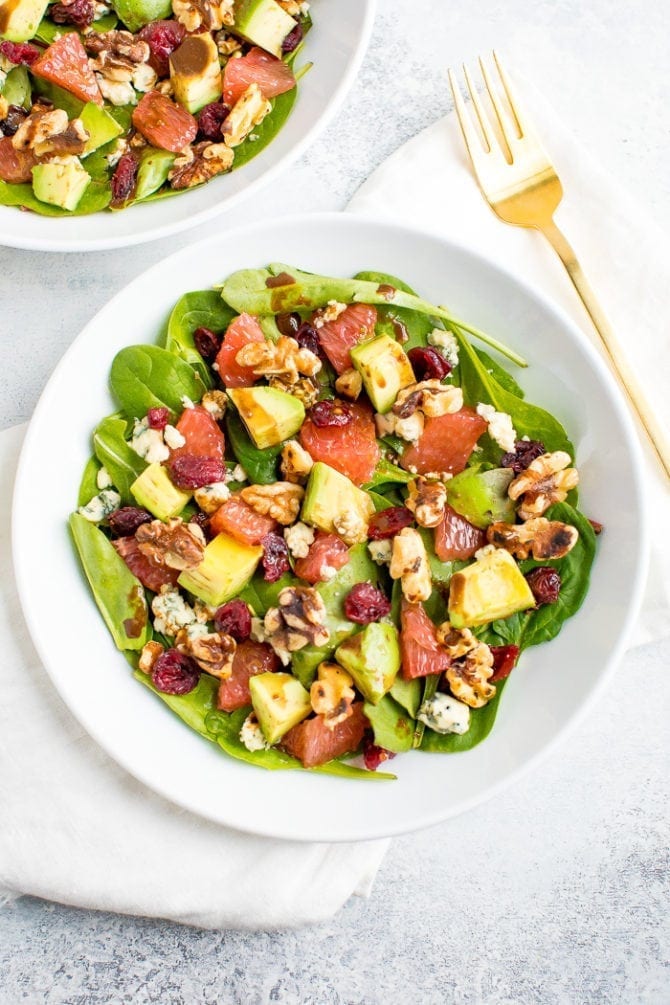 An overhead shot of a shallow bowl of grapefruit avocado salad with arugula.