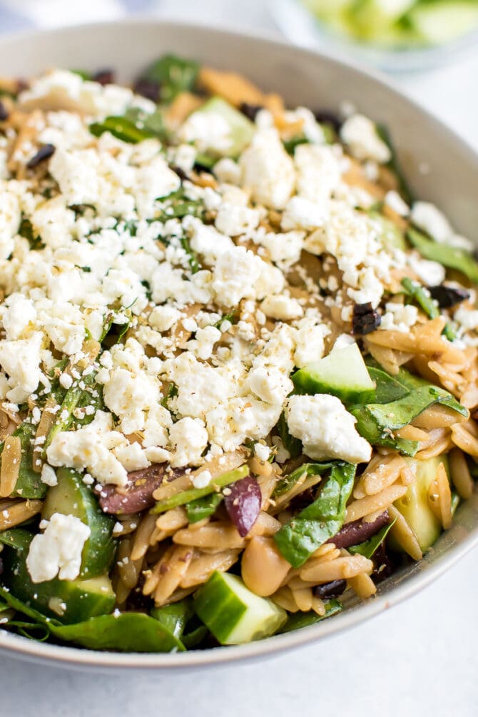 Orzo pasta salad in a bowl, topped with feta.