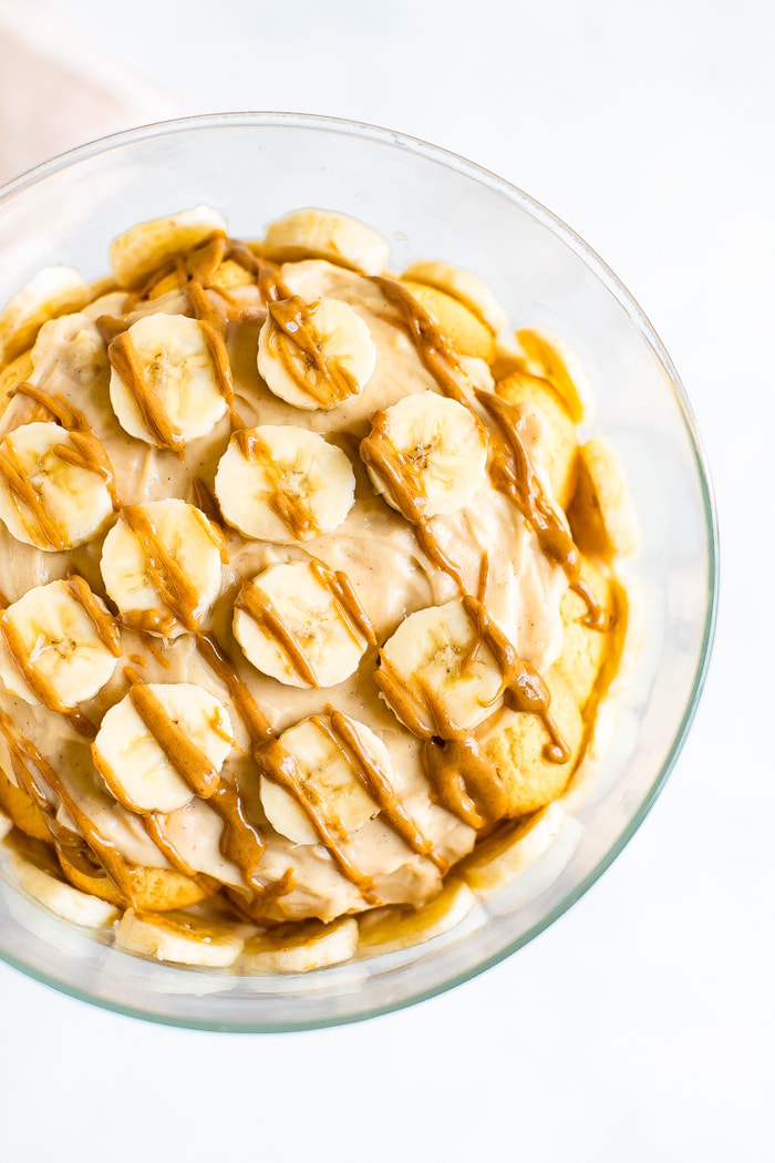 Peanut butter banana pudding topped with slices of bananas and a drizzle of peanut butter.