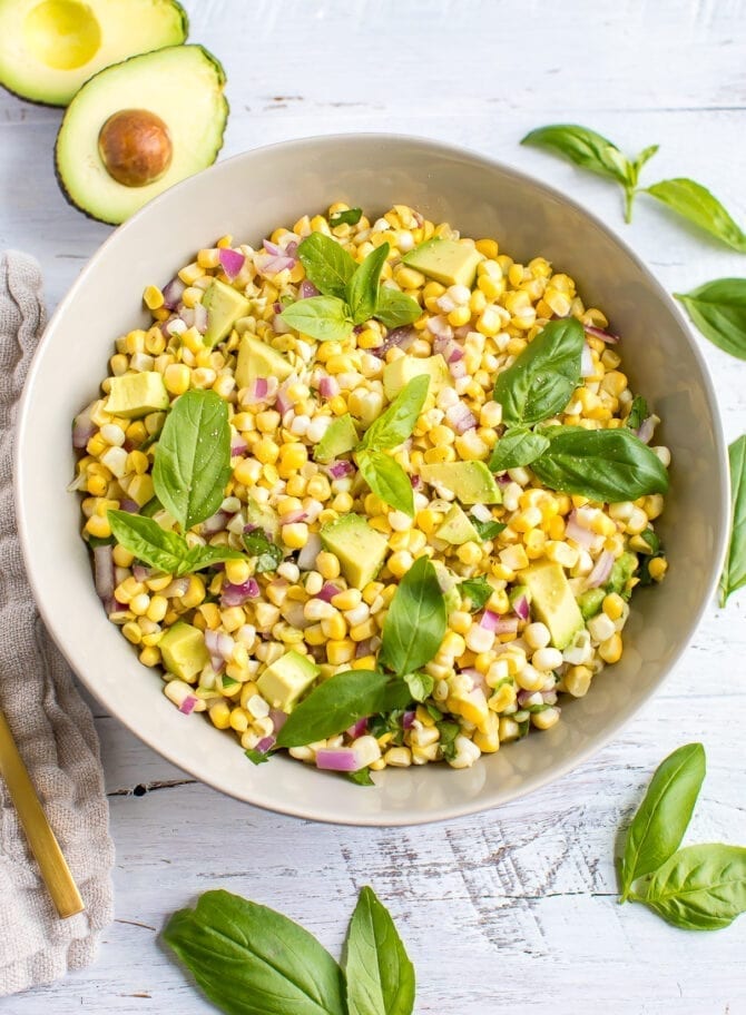 Avocado and corn salad topped with fresh basil