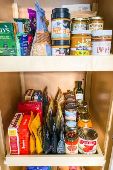 Pantry staples stocked in a pantry like peanut butter, canned goods and bagged foods.