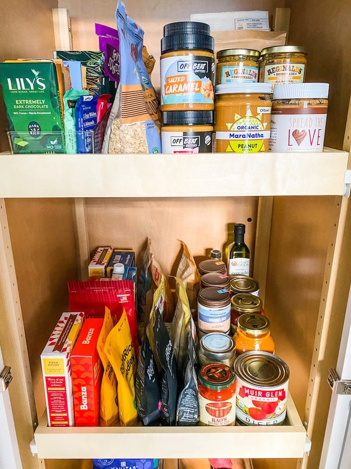 Pantry staples stocked in a pantry like peanut butter, canned goods and bagged foods.