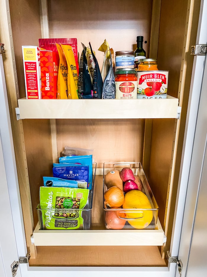 Pantry stocked with vegetables and canned goods and dry goods.