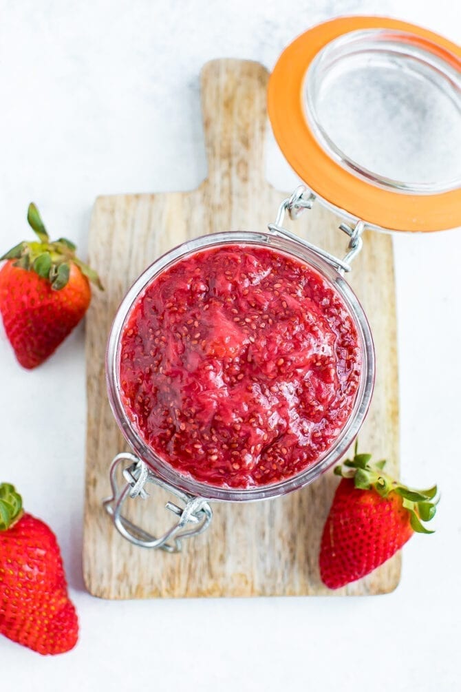 Overhead shot of strawberry chia jam in a glass jar. 