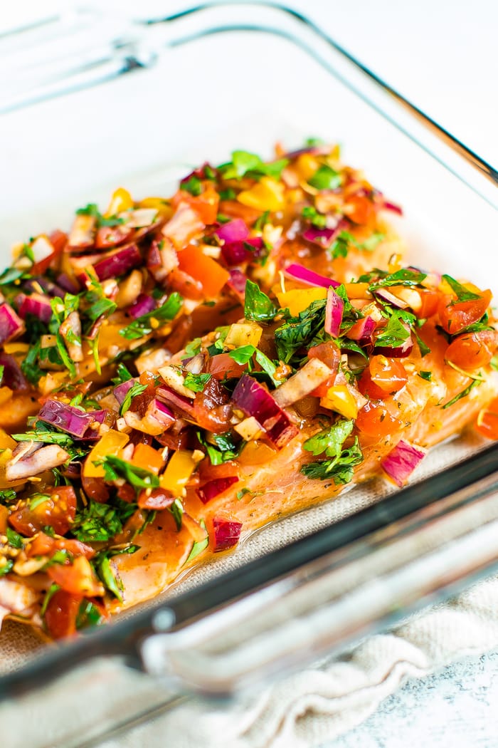 Glass baking dish with baked salmon with herbs and lime.