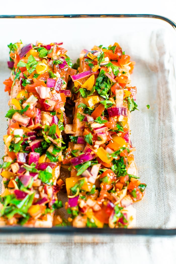 Glass baking dish with baked salmon with herbs and lime.