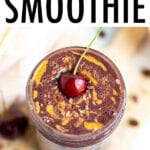 Mocha Cherry Smoothie in a glass mason jar topped with cacao nibs, a swirl of almond butter, and a cherry.