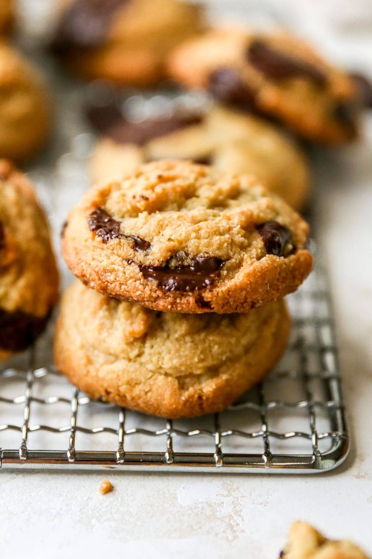 Stack of a couple chocolate chip cookies on a wire rack.