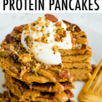 Stack of butternut squash pancakes topped with peanut butter, maple syrup, granola, and yogurt.