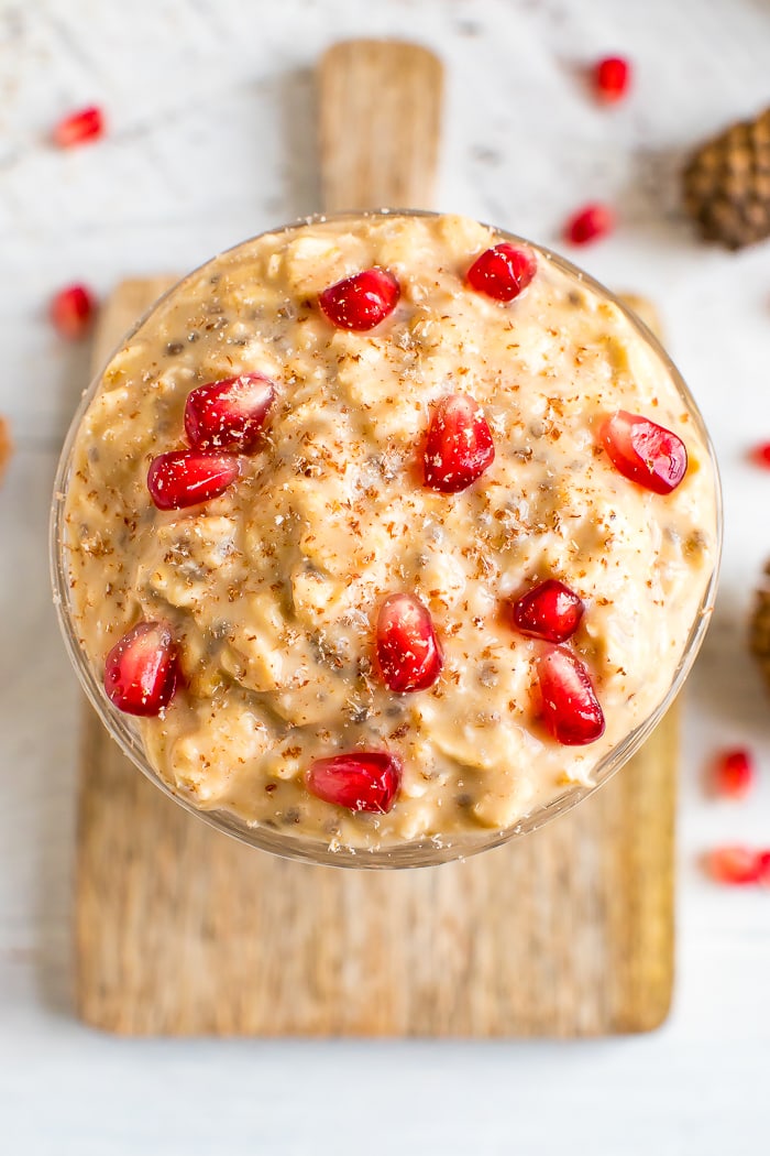 Healthy eggnog overnight oats topped with pomegranate and freshly ground nutmeg.