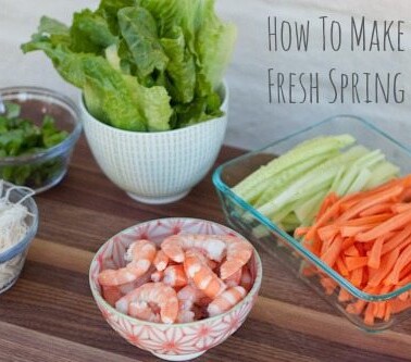 Ingredients for fresh spring rolls arranged in bowls on a cutting board.