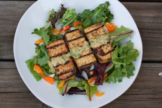 Overhead photo of a plate with lemon basil tofu on a bed of mixed greens.