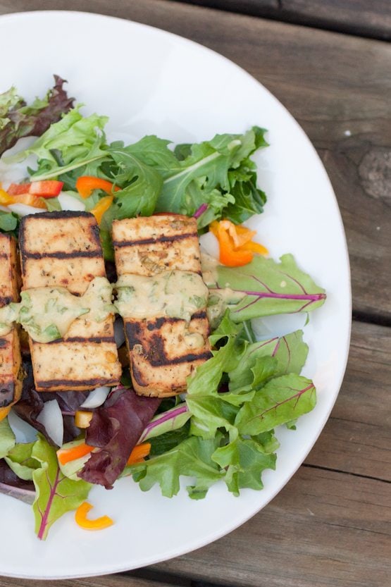 Overhead photo of a plate with lemon basil tofu on a bed of mixed greens.