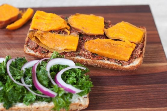 A sandwich being made, with two slices of bread holding different toppings.