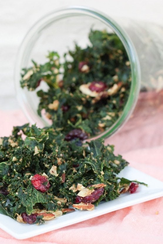 A jar of kale granola spilling out onto a square plate.