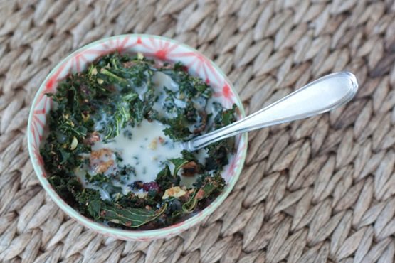 A bowl of kale granola served with milk.