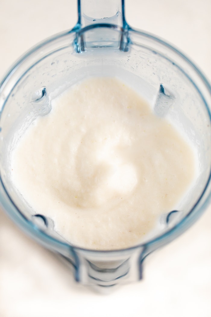Overhead shot of a skinny coconut daiquiri in a blender.