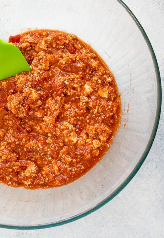 Tofu and marinara sauce mixed in a bowl to make vegetarian meat sauce.