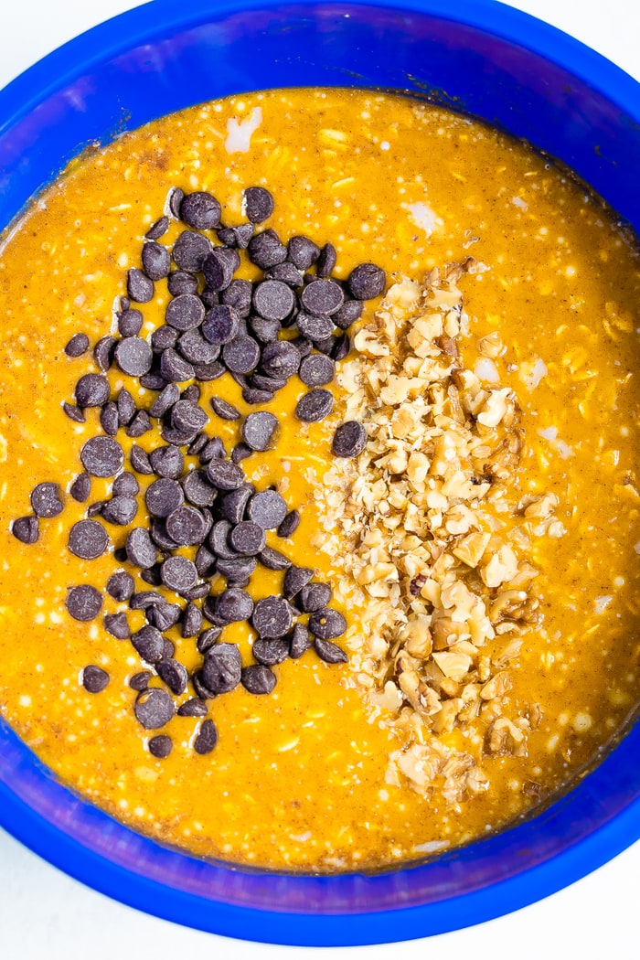 Bowl with mixture of the baked pumpkin oatmeal cups. Mixture includes pumpkin, oatmeal, walnuts, and chocolate chips.