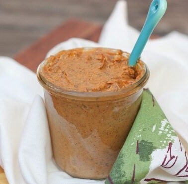 A jar of pumpkin almond butter sitting on a dish towel.