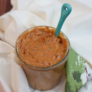 A jar of pumpkin almond butter sitting on a dish towel.