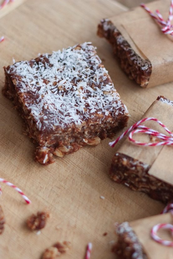 Healthy no bake chocolate coconut bars with coconut flakes on top.