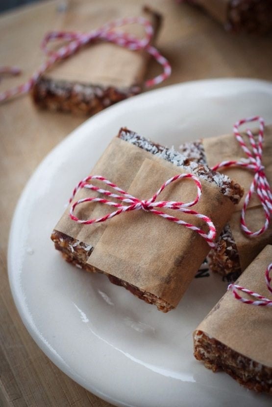 Healthy no bake chocolate coconut bars wrapped in parchment with red and white twine. 