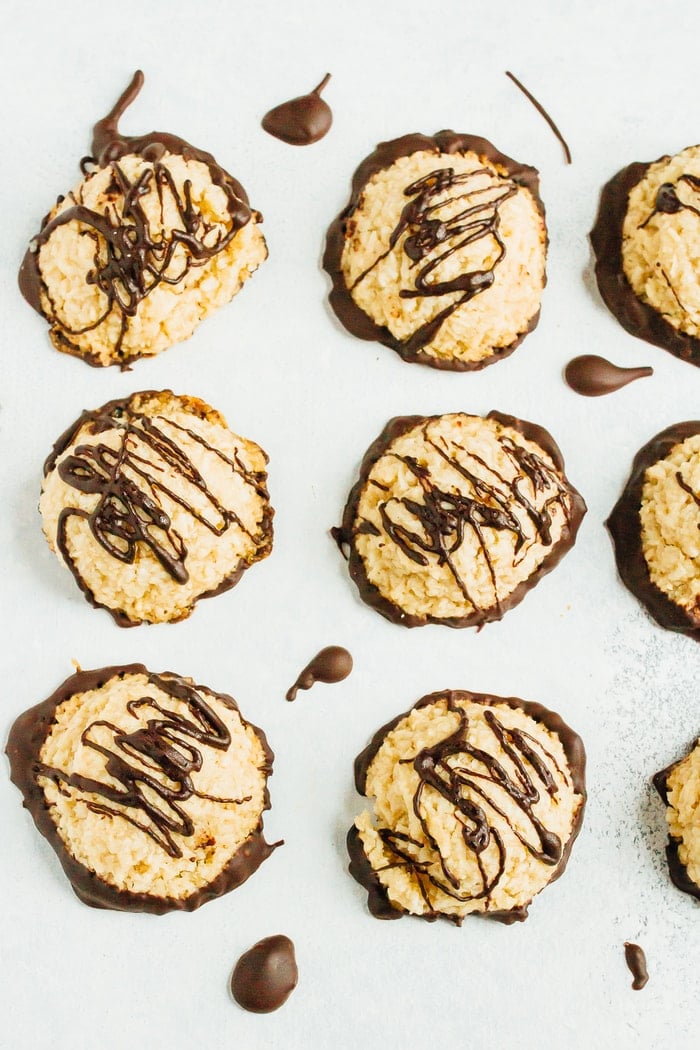 Six macaroons drizzled with dark chocolate, viewed from above.