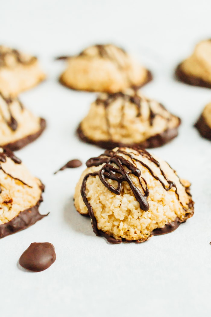 A tray of macaroons drizzled with dark chocolate.