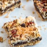Healthier square magic cookie bars. An almond flour cookie crust topped with coconut caramel, coconut, pecans, and chocolate chips.
