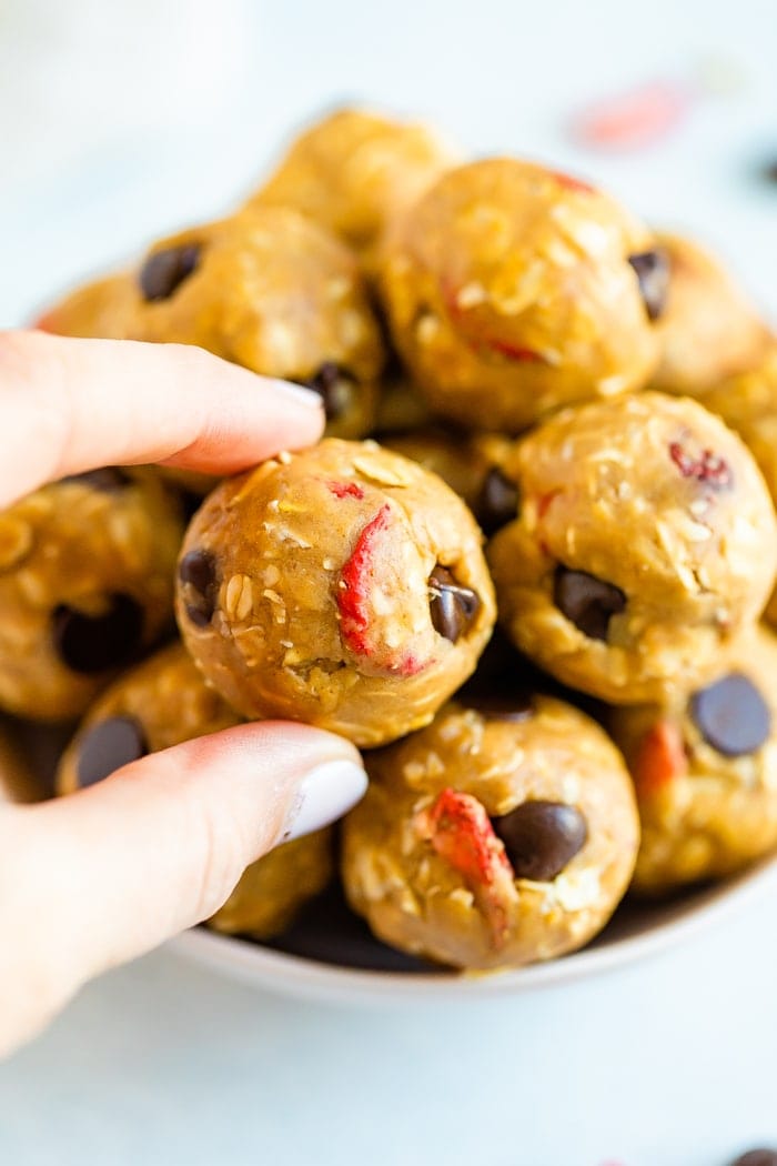 Hand holding a peanut butter and jelly protein ball.