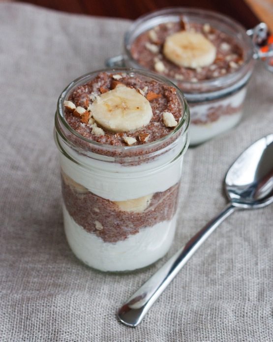 A jar of banana nut teff parfait with a silver spoon.