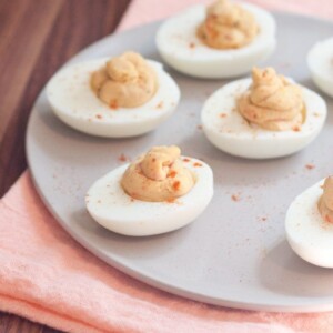 White plate with 5 hummus deviled eggs.