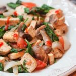 White plate with lean and green tofu in focus.