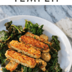 Lemon garlic tempeh slices over a bed of cooked kale. Text above says "Lemon Garlic Tempeh"