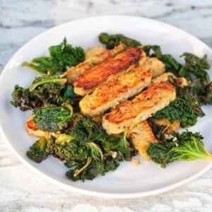 Lemon garlic tempeh slices over a bed of cooked kale.