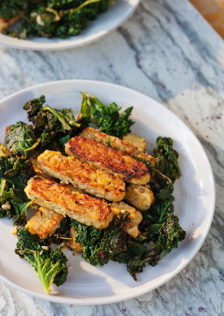 Lemon garlic tempeh slices over a bed of cooked kale. 