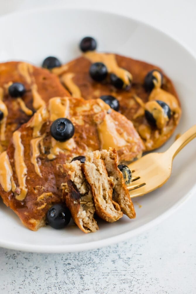 Blueberry protein pancakes with a bite taken out of it on a fork.