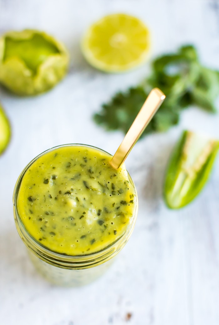 Chopt Mexican Goddess with tomatillos and avocado in a mason jar with a gold spoon. 