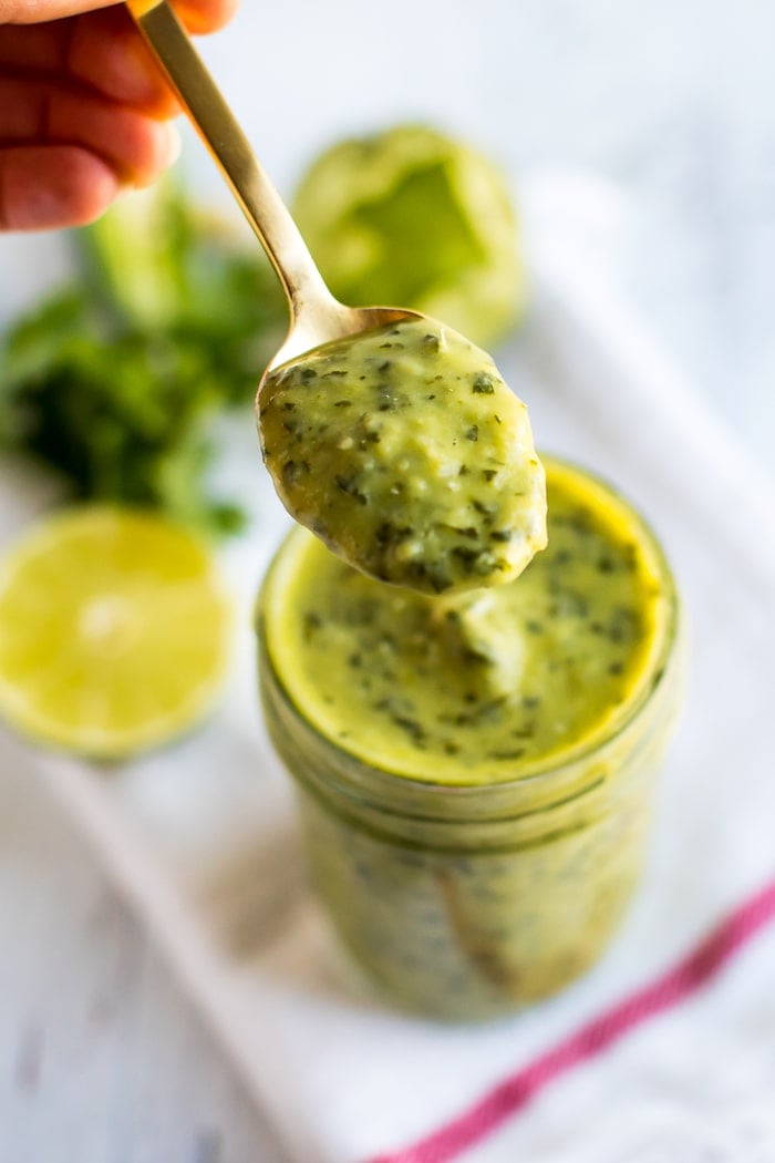 Chopt Mexican Goddess with tomatillos and avocado in a mason jar with a gold spoon.