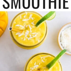 Glasses of avocado mango smoothies garnished with coconut flakes and lime slices.