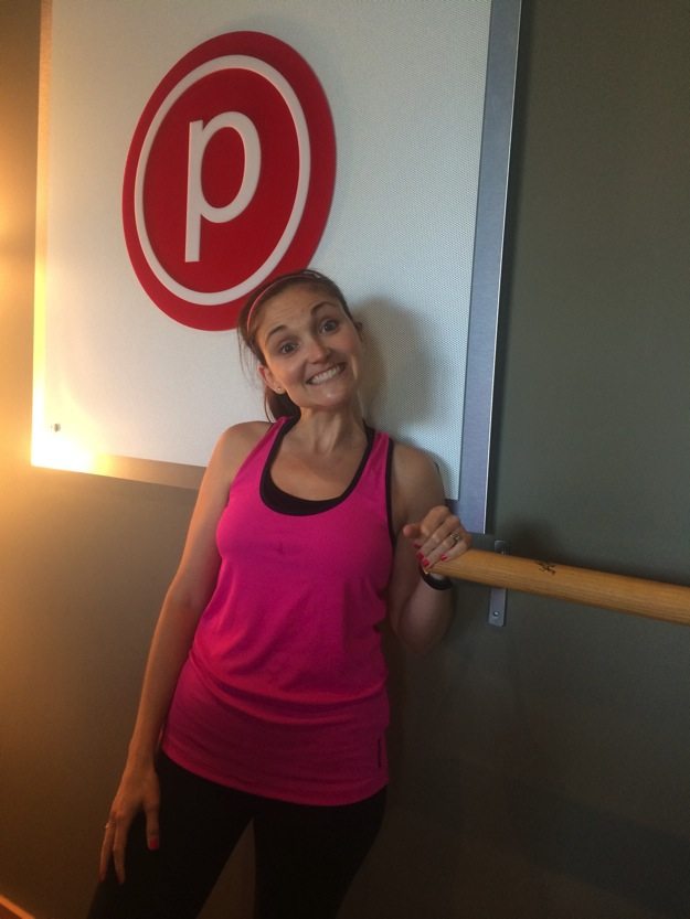 Girl in pink tank top and black pants inside barre studio