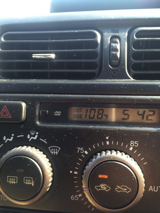 A picture of a car dashboard showing that it was 108 degrees Fahrenheit outside.