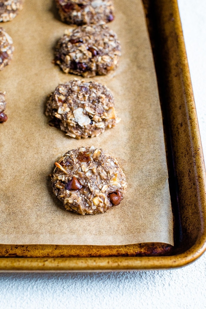 Cookie sheet with baked oatmeal chia cookies with coconut and chocolate chips.