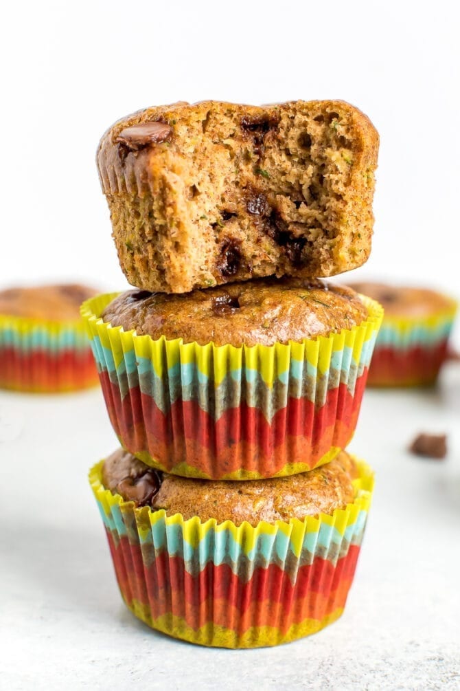 Stack of three muffins. The top muffin has a bite taken out of it.