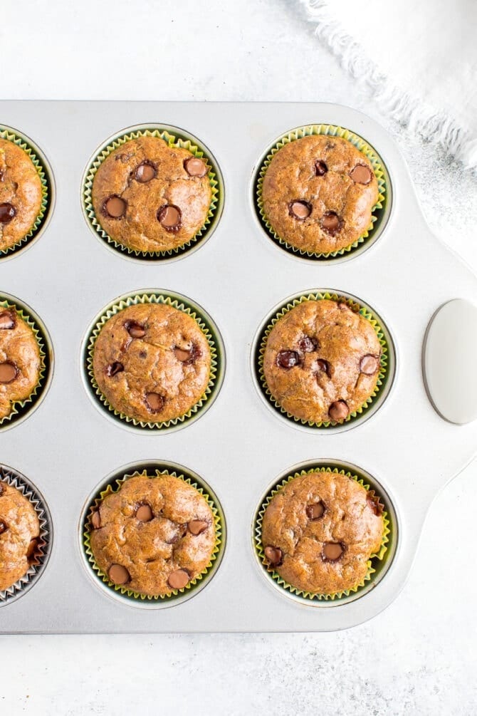 Muffin tin with chocolate chip flourless zucchini muffins.